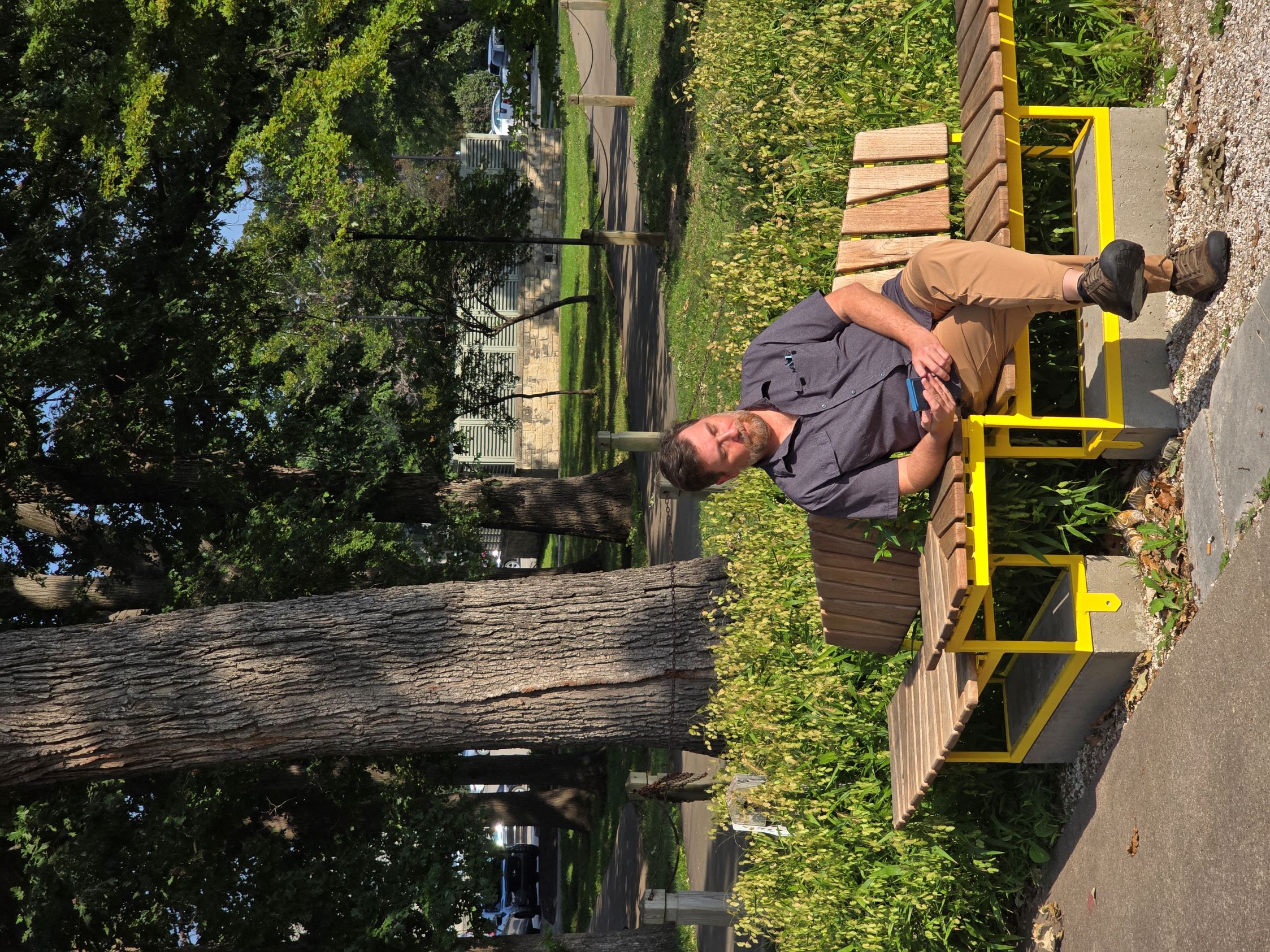 Man waiting, seated on one of the three elements of Meadow Seating.